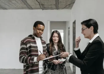 agent man signs document couple property real estate