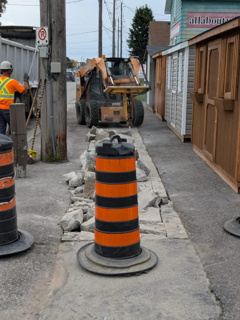 Who Is Paying for Oshawa Sidewalk Work at 109 Bloor Street East? Skid-steer removing sidewalk concrete beside businesses on Bloor Street East in Oshawa