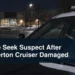 Investigator examines damaged cruiser windshield wipers with the headline Police Seek Suspect After Beaverton Cruiser Damaged
