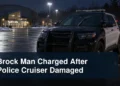 Damaged windshield wiper on a police cruiser outside a community arena with the headline Brock Man Charged After Police Cruiser Damaged