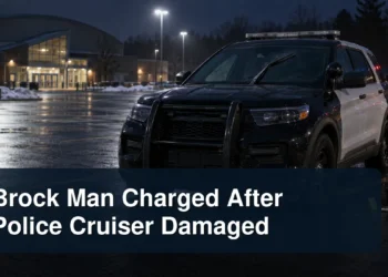 Damaged windshield wiper on a police cruiser outside a community arena with the headline Brock Man Charged After Police Cruiser Damaged