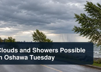 Windy Oshawa lakeshore beneath rain clouds with the headline Clouds and Showers Possible in Oshawa Tuesday