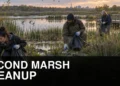 Volunteers collecting litter beside reeds at Oshawa Second Marsh