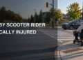 Neutral road-safety illustration of a mobility scooter rider at a Whitby intersection