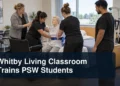 PSW students practising mobility support with a simulation mannequin under the headline Whitby Living Classroom Trains PSW Students
