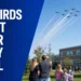 Canadian aerobatic aircraft flying over a Whitby schoolyard during a commemorative flypast