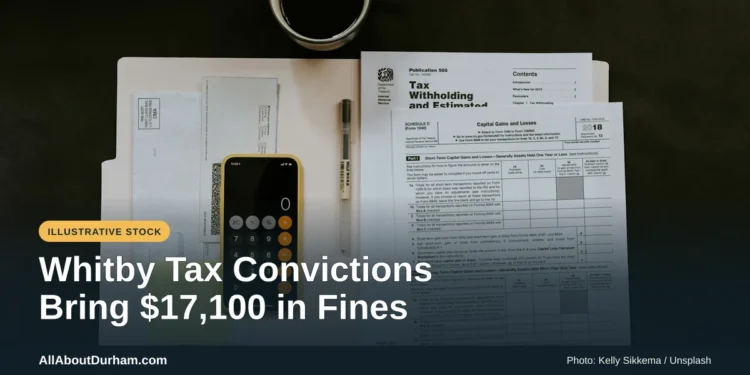 Illustrative stock photo: Tax paperwork, phone and pen on a desk. Photo by Kelly Sikkema on Unsplash. Headline: Whitby Tax Convictions Bring $17,100 in Fines. AllAboutDurham.com.