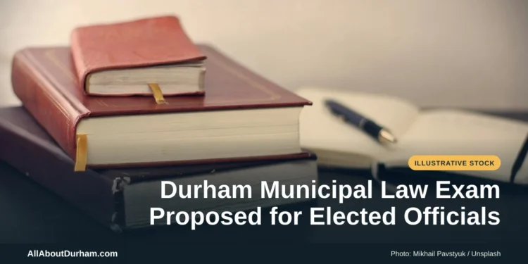 Illustrative stock photo: Books and an open notebook on a desk. Photo by Mikhail Pavstyuk on Unsplash. Headline: Durham Municipal Law Exam Proposed for Elected Officials. AllAboutDurham.com.