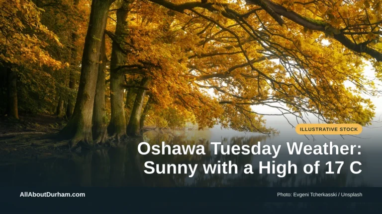 Illustrative stock photo: A lake surrounded by trees with yellow autumn leaves. Photo by Evgeni Tcherkasski on Unsplash. Headline: Oshawa Tuesday Weather: Sunny with a High of 17 C. AllAboutDurham.com.